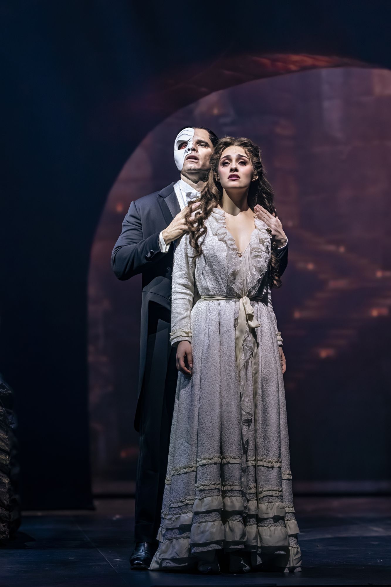 The Phantom and Christine Daaé in full costume on the darkened stage
